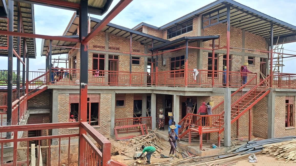 Builders completing the guesthouse's connected stairs, balconies, and covered courtyard galleries