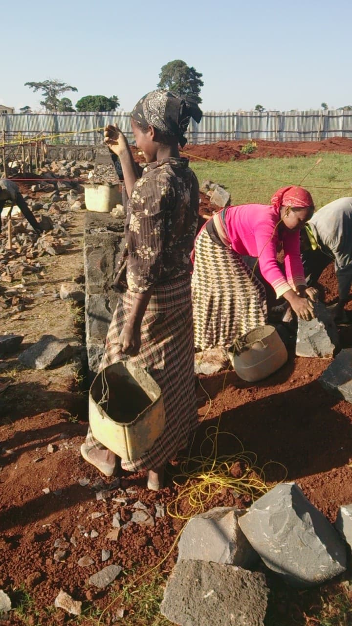 Women carrying stone and mortar during foundation work for the Maternity Hospital in Bahir Dar