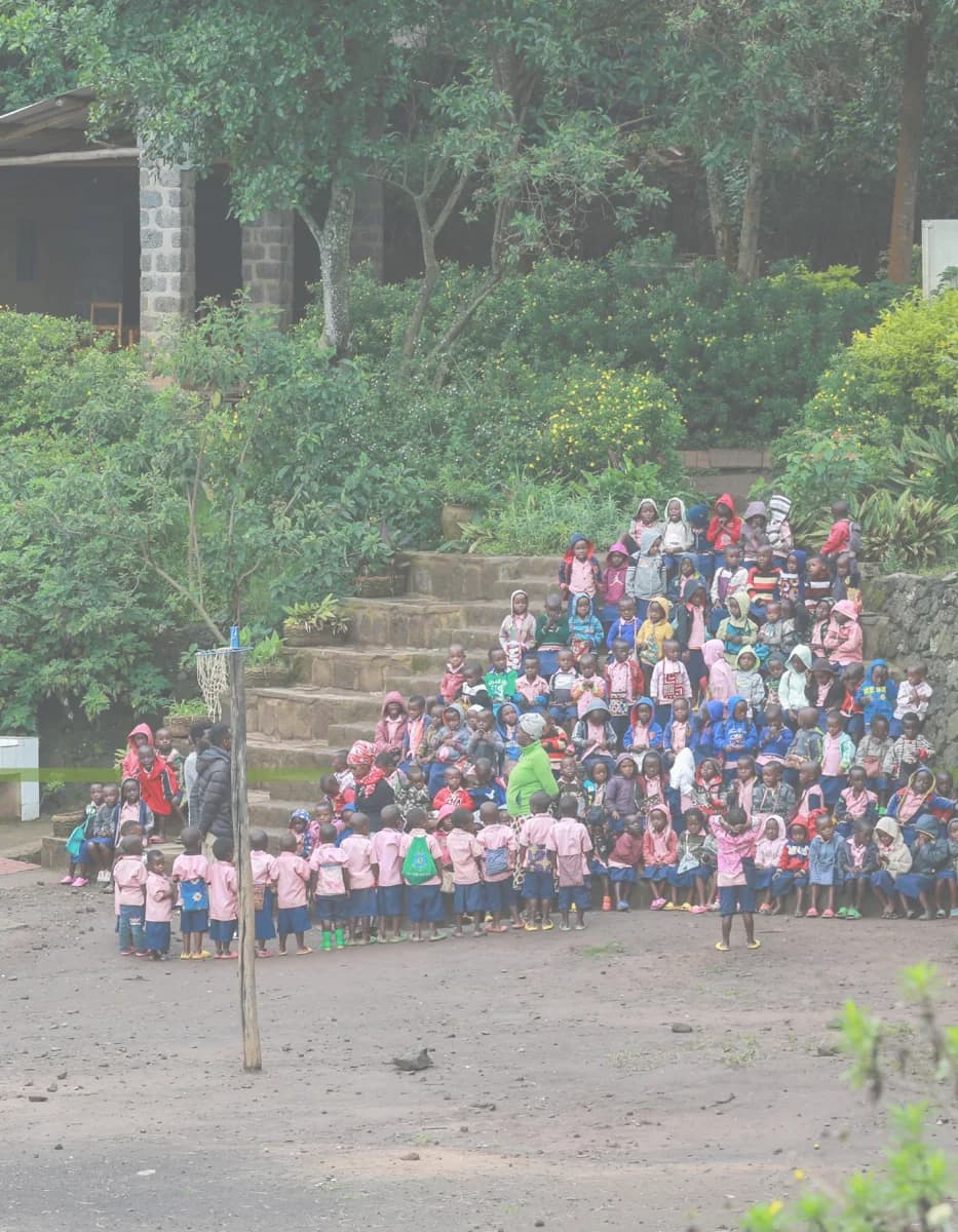 Children and community members gathered on a terraced hillside