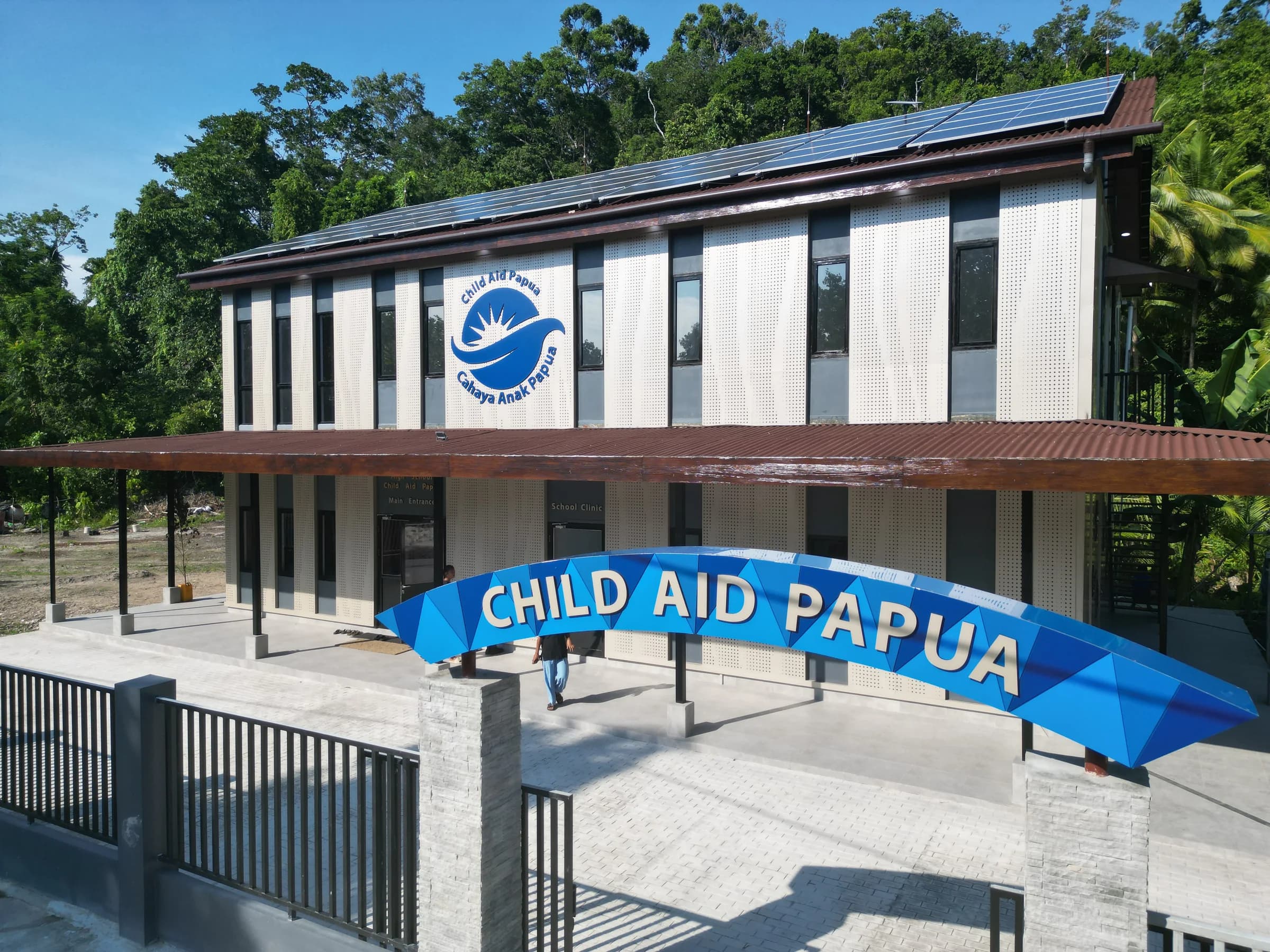 The completed Blue Ocean School building in Raja Ampat, with solar panels above its shaded entrance