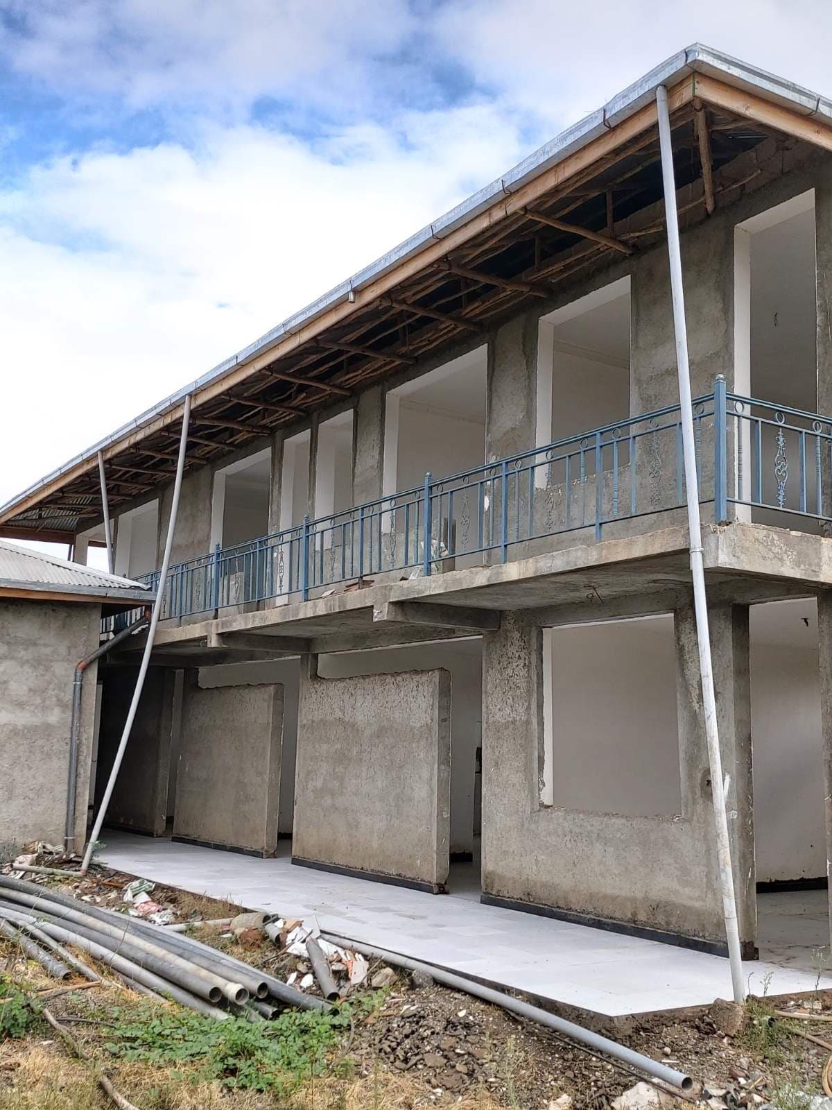 The two-story hospital exterior with its long covered balcony nearing completion