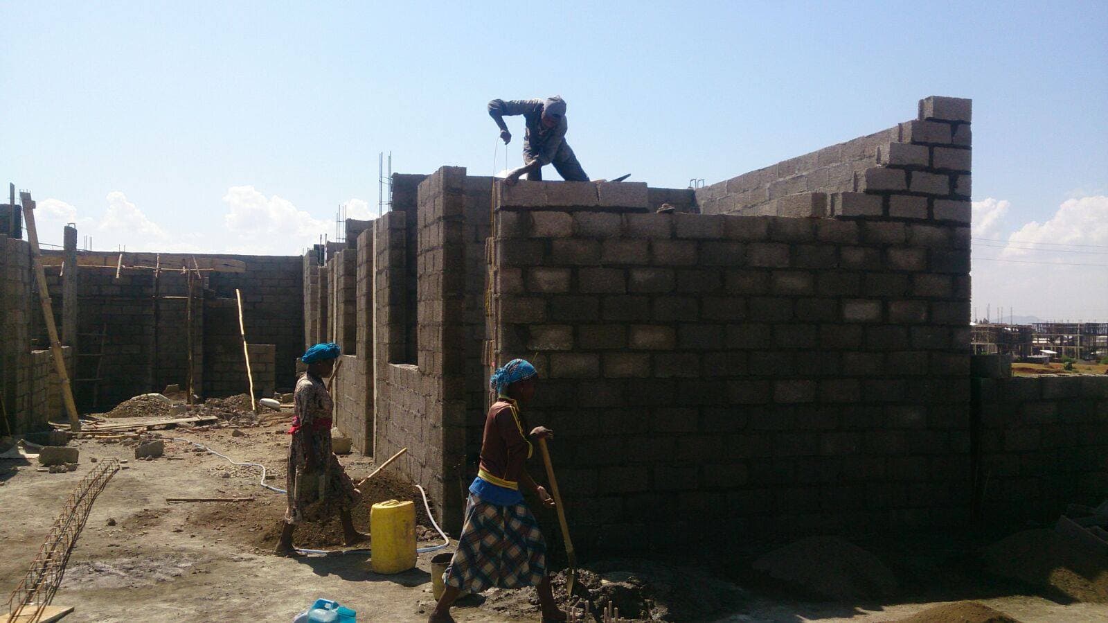 Builders laying concrete masonry walls at the Maternity Hospital construction site
